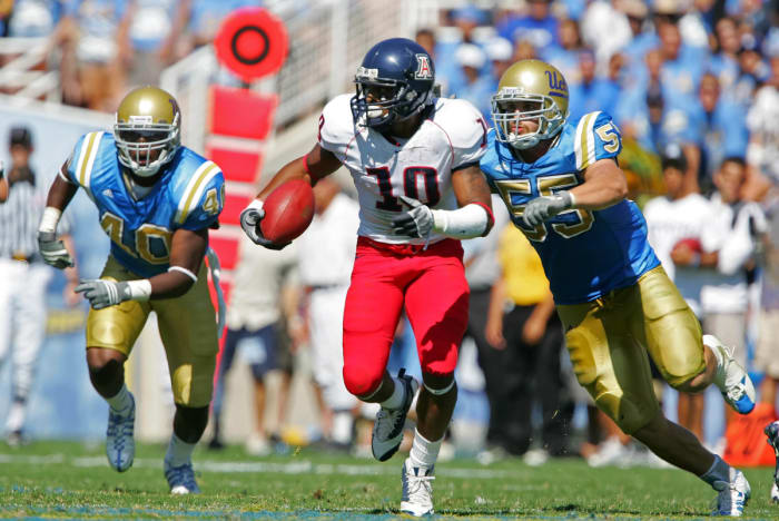 Arizona Wildcats wide receiver Mike Thomas (10) runs against the defense of UCLA Bruins guard Sonny Tevaga (55) and linebacker Akeem Ayers (40) in the second half at the Rose Bowl. Arizona defeated UCLA 31-10.